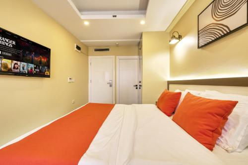 a bedroom with a large bed with orange pillows at Duck Otel in Istanbul