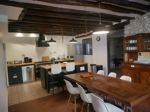 - une cuisine avec une table en bois et des chaises blanches dans l'établissement Auberge des Alouettes - Châlo St Mars 91, à Châlo-Saint-Mars