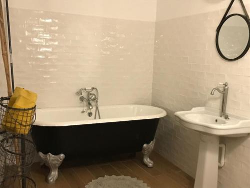 une salle de bain avec une baignoire et un lavabo dans l'établissement Auberge des Alouettes - Châlo St Mars 91, à Châlo-Saint-Mars