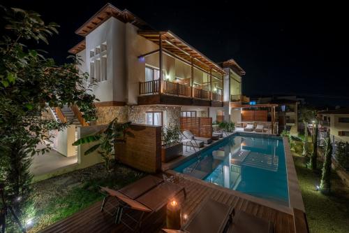 a villa with a swimming pool at night at Anima Residence in Nea Roda