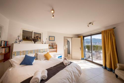 une chambre avec un grand lit et une grande fenêtre dans l'établissement 06C-Villa for 8 persons with pool near Nice, à Tourrette-Levens