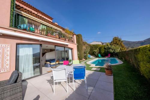 un patio avec une table et des chaises et une piscine dans l'établissement 06C-Villa for 8 persons with pool near Nice, à Tourrette-Levens