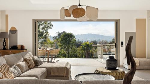 un salon avec un canapé et une grande fenêtre dans l'établissement Villa Arty Riviera, à Saint-Paul-de-Vence