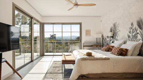 une chambre avec un grand lit et une grande fenêtre dans l'établissement Villa Arty Riviera, à Saint-Paul-de-Vence