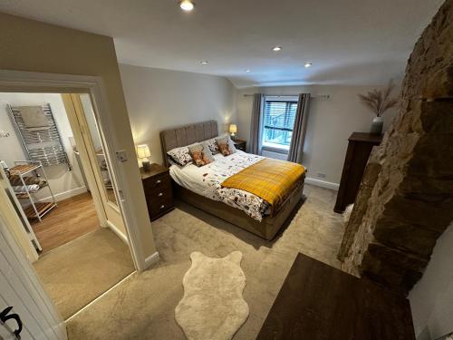 ein Schlafzimmer mit einem Bett und einer Katze darin in der Unterkunft Whitebrook Cottage in Mellor