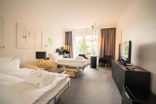 a hotel room with two beds and a television at Bernstein Hotel Villa Kastania in Berlin