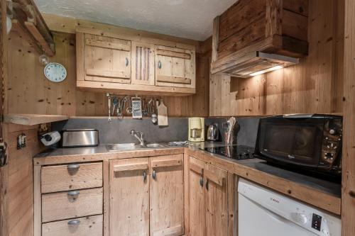 - une cuisine avec des placards en bois et un four micro-ondes dans l'établissement Le Gite - Le Mont Joly - 6 pax, à Saint-Gervais-les-Bains