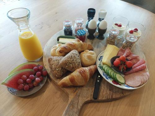 a wooden table with a plate of bread and fruit at Smaakvol Slochteren in Slochteren