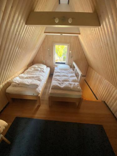 a small room with two beds in a attic at Bootshaus am Inselseekanal in Güstrow