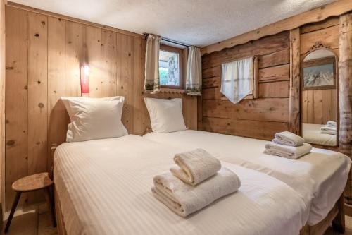 deux lits jumeaux dans une chambre aux murs en bois dans l'établissement Le Gite - Le Mont d'Arbois - 5 pax, à Saint-Gervais-les-Bains
