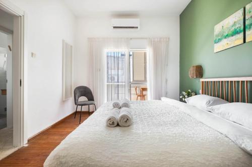 a bedroom with a bed with two towels on it at Ben Yehuda Elegant City Retreat with Shelter by Sea N Rent in Tel Aviv