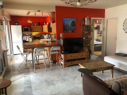 un salon avec une cuisine et un salon avec une table dans l'établissement Appart trois chambres et terrasse, à Sète