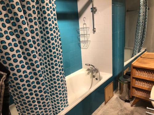 La salle de bains est pourvue d'un rideau de douche et d'une baignoire. dans l'établissement Appart trois chambres et terrasse, à Sète