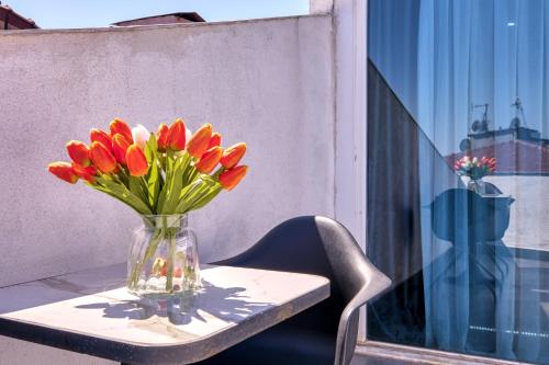 a vase of flowers on a table on a balcony at Duck Otel in Istanbul