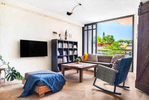 a living room with a couch and a table at Ramat Hasharon Duplex Rooftop Oasis by Sea N Rent in Ramat Hash Sharon