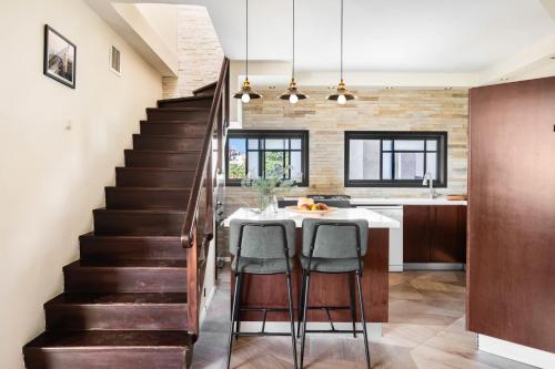 a kitchen with stairs and a table with chairs at Ramat Hasharon Duplex Rooftop Oasis by Sea N Rent in Ramat Hash Sharon