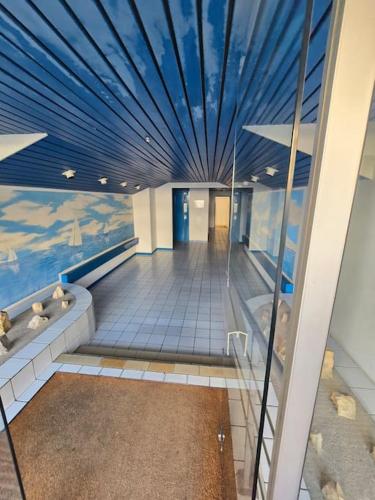 un couloir avec un plafond bleu dans un bâtiment dans l'établissement Charmant Studio au Cœur de La Grande Motte, à 2 min de la Plage, à La Grande Motte
