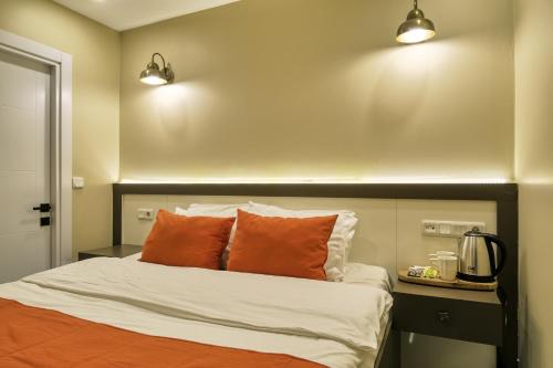 a bedroom with a bed with two orange pillows at Duck Otel in Istanbul