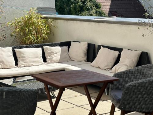 a couch with pillows on a patio with a table at Terrassentraum für 2 in Vienna