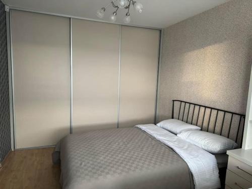 a bedroom with a bed with two pillows on it at Spacious&cozy south apartment in Šiauliai
