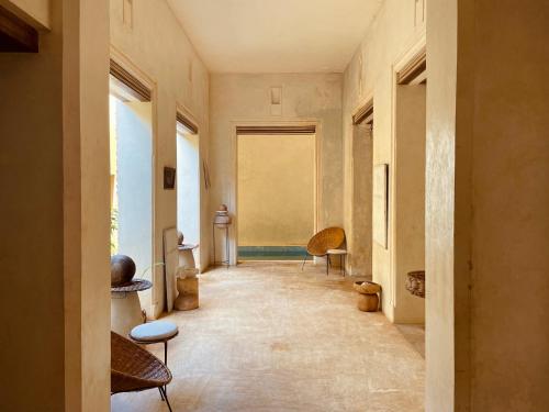 a hallway with chairs and a window in a building at Swahili Dreams Apartments in Lamu