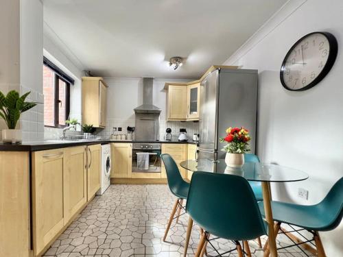 a kitchen with a table and a clock on the wall at Perfect Very Central and Peaceful Oxford Home with Free Parking & Private Garden - in Oxford
