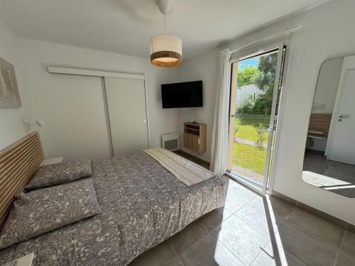 une chambre avec un lit, une télévision et une fenêtre dans l'établissement Jardin Secret A04, à Antibes
