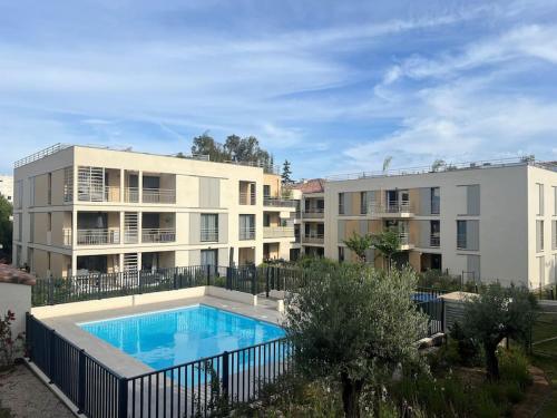 un immeuble avec piscine en face d'un immeuble dans l'établissement Jardin Secret A04, à Antibes