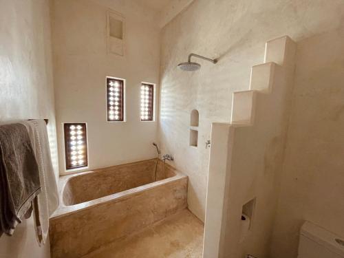 a bathroom with a large tub in a room at Swahili Dreams Apartments in Lamu