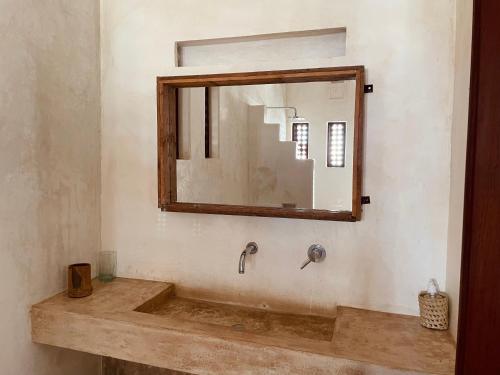 a bathroom with a sink and a mirror at Swahili Dreams Apartments in Lamu