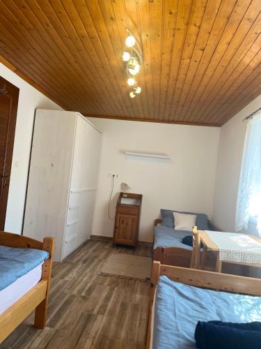 a room with two beds and a wooden ceiling at Ikervár-lak in Ikervár
