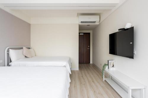 a bedroom with two beds and a flat screen tv at 109台北旅館-台北109青旅 109 Taipei Hotel - Taipei 109 Hostel in Taipei