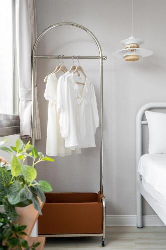 a metal clothes rack in a bedroom with a bed at 109台北旅館-台北109青旅 109 Taipei Hotel - Taipei 109 Hostel in Taipei