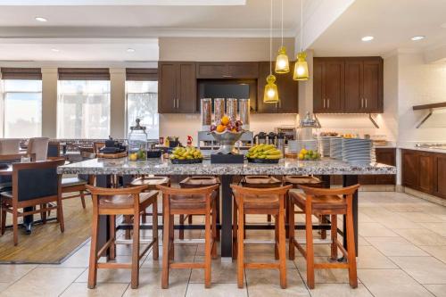 a kitchen with a large island with wooden chairs at Hilton Garden Inn Lexington in Lexington