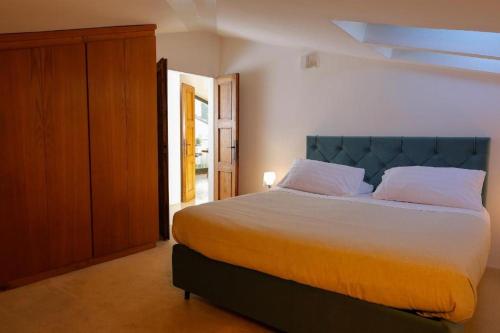 a bedroom with a large bed with a blue headboard at villa centro Greve in Chianti in Greve in Chianti