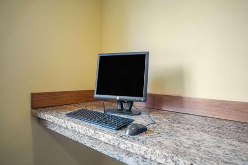 a computer monitor and a keyboard and mouse on a counter at Days Inn by Wyndham Evansdale Waterloo in Evansdale