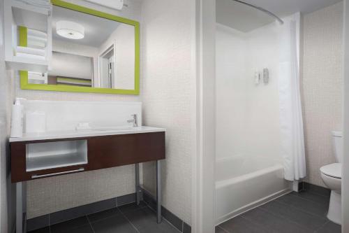 a bathroom with a sink and a toilet and a mirror at Hampton Inn & Suites Atlanta-Six Flags in Lithia Springs
