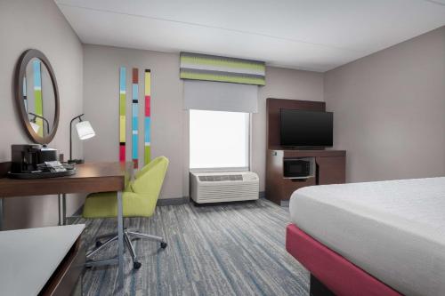 a hotel room with a bed and a desk and a television at Hampton Inn & Suites Atlanta-Six Flags in Lithia Springs