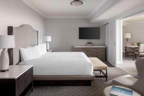 a hotel room with a white bed and a chair at Hyatt Regency Huntington Beach Resort and Spa in Huntington Beach