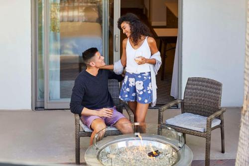 a woman standing next to a man sitting in a chair at Hyatt Regency Huntington Beach Resort and Spa in Huntington Beach