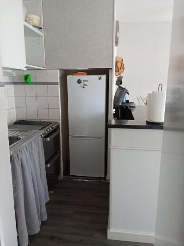 Il comprend une cuisine équipée d'un réfrigérateur blanc et d'une cuisinière. dans l'établissement Studio tout équipé refait à neuf, à Balaruc-les-Bains