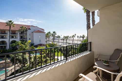 a balcony with a view of the beach and palm trees at Hyatt Regency Huntington Beach Resort and Spa in Huntington Beach