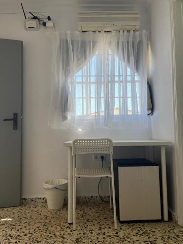 a desk with a window and a chair in a room at Alojamientos La Menúa in Los Badalejos
