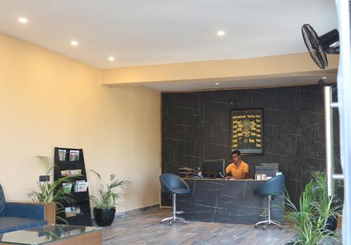 a man is sitting at a counter in a lobby at Bella Basera in Kumbhalgarh