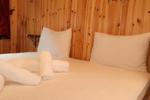 a bedroom with a bed with white sheets and pillows at TUVA VİLLA Bungalov in Çamlıhemşin
