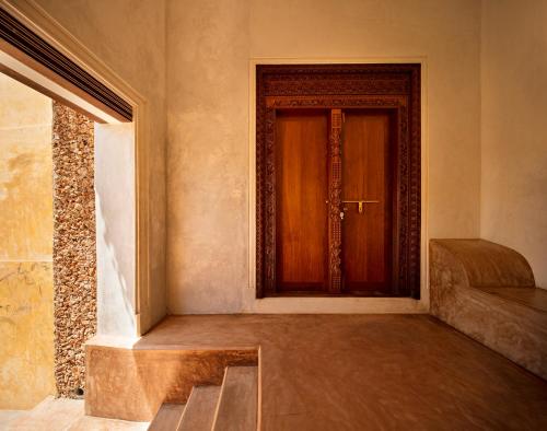 a hallway with a wooden door in a building at Swahili Dreams Apartments in Lamu
