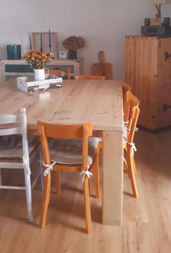 une table en bois avec quatre chaises autour dans l'établissement Jolie maison de pêcheur en bord de mer, à Port-Louis