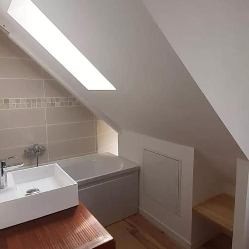 une salle de bain avec un lavabo et une baignoire dans l'établissement Jolie maison de pêcheur en bord de mer, à Port-Louis