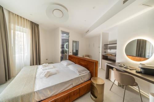 a bedroom with a bed and a desk and a mirror at Ypnos Rooms in Naples