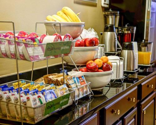 a counter with bowls of food and bowls of fruit at Comfort Suites Gadsden Attalla in Gadsden